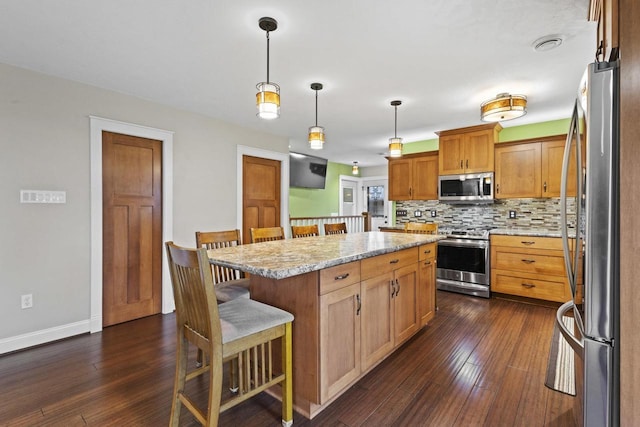 4350 S US Highway 45, Oshkosh, WI 54902 - kitchen featuring appliances with stainless steel finishes, backsplash, a kitchen bar, and dark wood finished floors