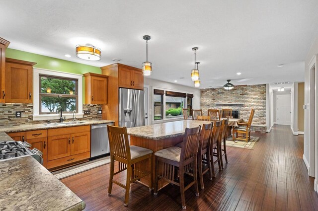 4350 S US Highway 45, Oshkosh, WI 54902 - kitchen featuring appliances with stainless steel finishes, brown cabinetry, backsplash, dark wood finished floors, and recessed lighting