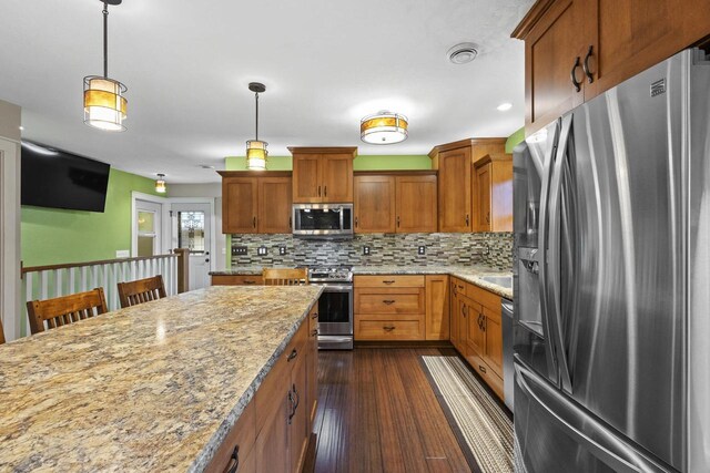 4350 S US Highway 45, Oshkosh, WI 54902 - kitchen with stainless steel appliances, dark wood-type flooring, backsplash, pendant lighting, and light stone countertops