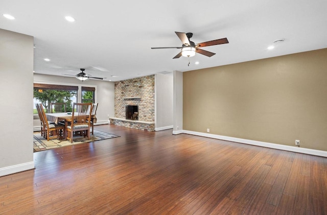 4350 S US Highway 45, Oshkosh, WI 54902 - living room featuring a ceiling fan, wood finished floors, a baseboard radiator, recessed lighting, and a fireplace