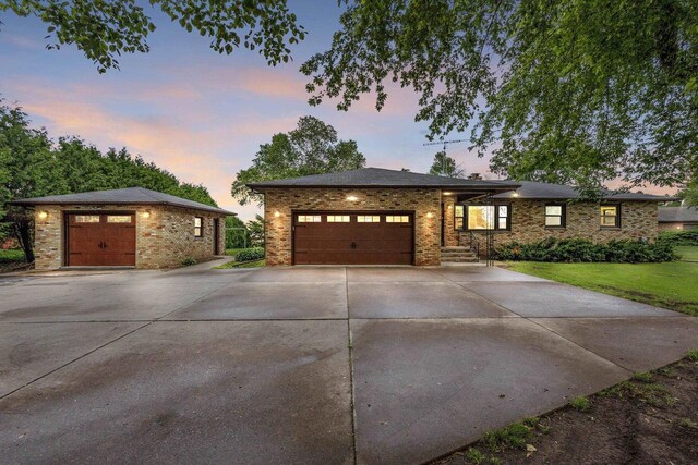 4350 S US Highway 45, Oshkosh, WI 54902 - view of front of home with driveway, brick siding, a yard, and a garage