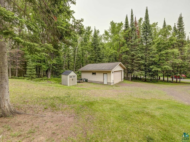 10811 S Patterson Rd, Solon Springs, WI 54873 - view of grassy yard with a garage, a storage unit, and a wooded view