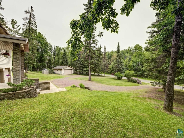 10811 S Patterson Rd, Solon Springs, WI 54873 - view of grassy yard featuring a storage shed, a garage, and a wooded view