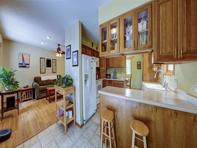 10811 S Patterson Rd, Solon Springs, WI 54873 - kitchen with white appliances, a peninsula, brown cabinetry, light countertops, and a textured ceiling