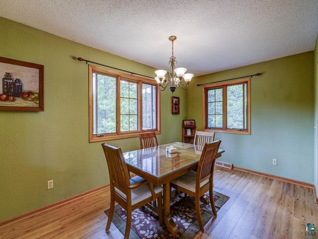 10811 S Patterson Rd, Solon Springs, WI 54873 - dining space featuring plenty of natural light, a chandelier, light wood-style flooring, and a textured ceiling