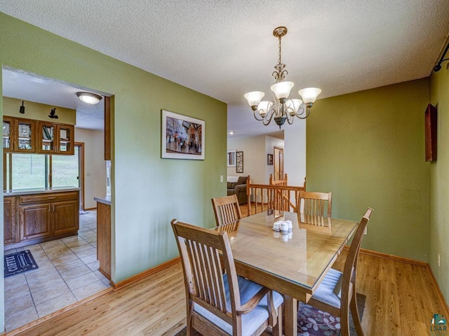 10811 S Patterson Rd, Solon Springs, WI 54873 - dining space with a chandelier, light wood-style flooring, and a textured ceiling