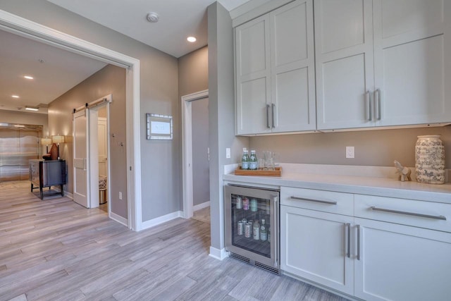 215 E Pleasant St Unit 304, Oconomowoc, WI 53066 - indoor dry bar featuring wine cooler, a barn door, light wood-style floors, and recessed lighting
