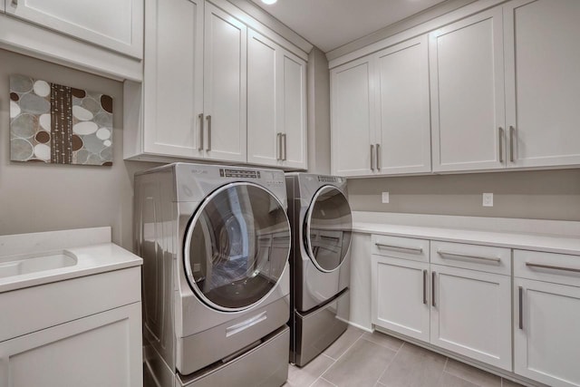 215 E Pleasant St Unit 304, Oconomowoc, WI 53066 - washroom with cabinet space, washer and clothes dryer, and light tile patterned floors