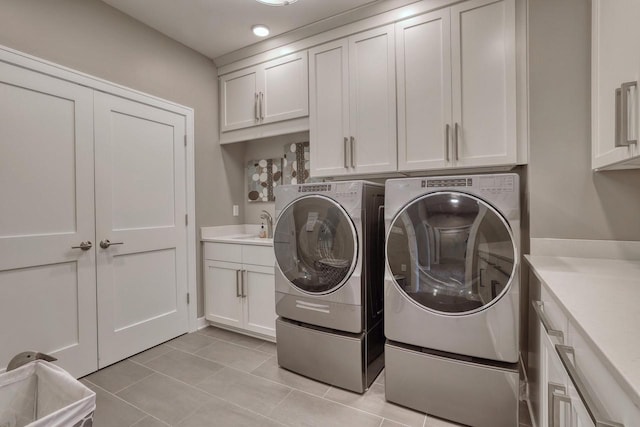 215 E Pleasant St Unit 304, Oconomowoc, WI 53066 - laundry area featuring washer and clothes dryer, cabinet space, and light tile patterned floors