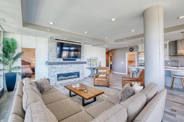 215 E Pleasant St Unit 304, Oconomowoc, WI 53066 - living room with light wood-style flooring, a stone fireplace, and recessed lighting