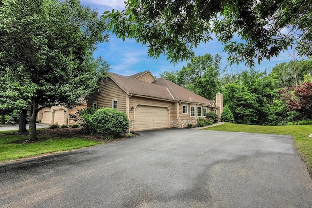 2855 River Birch Dr Unit D, Brookfield, WI 53045 - view of side of home featuring stone siding, an attached garage, a lawn, asphalt driveway, and a chimney