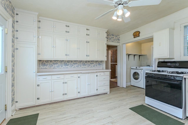 305 N Center Ave, Merrill, WI 54452 - kitchen with gas range oven, independent washer and dryer, white cabinets, and light wood-type flooring
