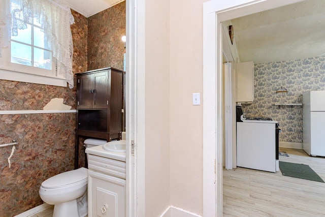 305 N Center Ave, Merrill, WI 54452 - bathroom with vanity, wallpapered walls, and wood finished floors