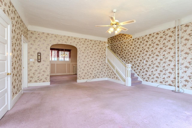 305 N Center Ave, Merrill, WI 54452 - carpeted spare room featuring arched walkways, a ceiling fan, wallpapered walls, and stairway