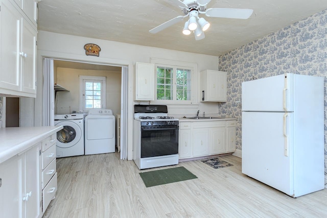 305 N Center Ave, Merrill, WI 54452 - kitchen with white appliances, wallpapered walls, washing machine and dryer, white cabinets, and ceiling fan