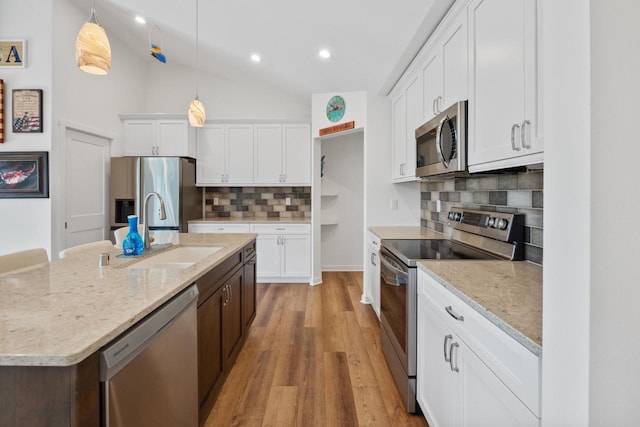 1451 Whalen Dr, Oconomowoc, WI 53066 - kitchen with appliances with stainless steel finishes, white cabinets, light wood-style flooring, decorative backsplash, and a kitchen island with sink