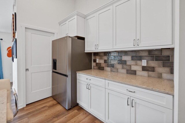 1451 Whalen Dr, Oconomowoc, WI 53066 - kitchen featuring stainless steel fridge with ice dispenser, decorative backsplash, white cabinetry, light wood-style flooring, and light stone countertops
