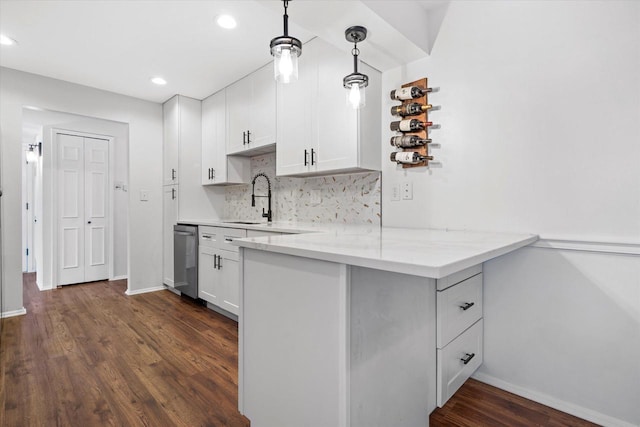 1152 Pilgrim Pkwy, Elm Grove, WI 53122 - kitchen featuring stainless steel dishwasher, a peninsula, white cabinetry, dark wood-type flooring, and decorative backsplash