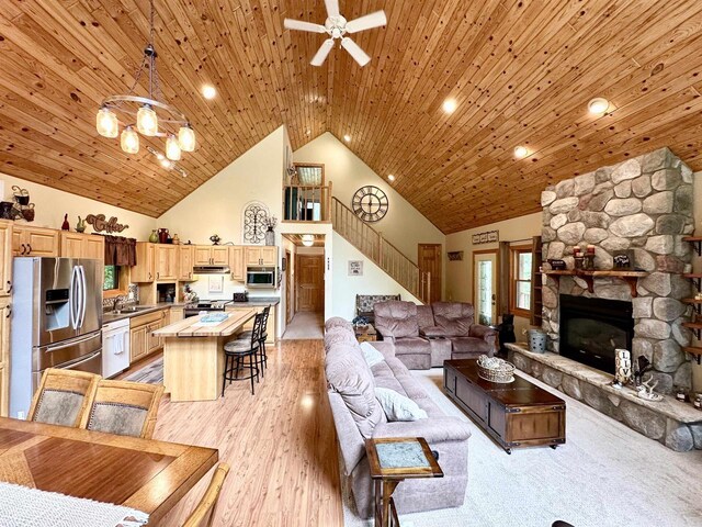 N6448 Neva Lake Rd, Deerbrook, WI 54424 - living room with stairway, high vaulted ceiling, ceiling fan, a fireplace, and a chandelier