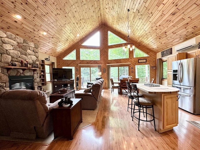 N6448 Neva Lake Rd, Deerbrook, WI 54424 - living room with a wall mounted AC, high vaulted ceiling, a stone fireplace, light wood finished floors, and wooden walls