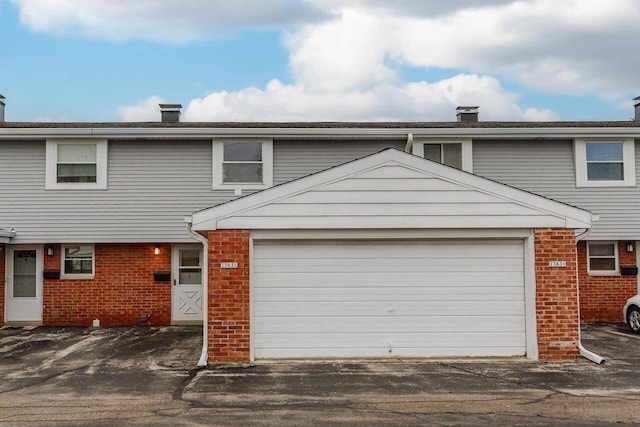 1363 Josephine St Unit E, Waukesha, WI 53186 - view of front of house with brick siding, a chimney, and a garage