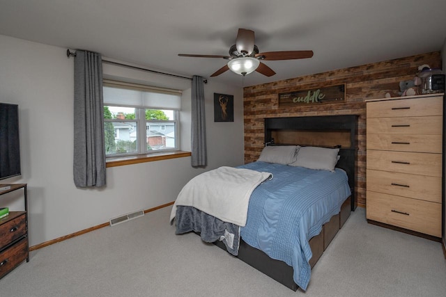 1363 Josephine St Unit E, Waukesha, WI 53186 - carpeted bedroom featuring wooden walls, a ceiling fan, and an accent wall