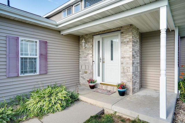 408 Juniper St, Brooklyn, WI 53521 - view of exterior entry featuring covered porch and brick siding
