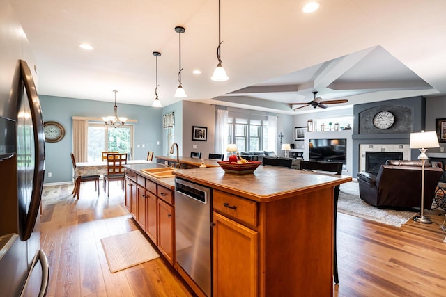 1255 Winterberry Rd, Oconomowoc, WI 53066 - kitchen with dishwasher, black fridge, a large fireplace, brown cabinetry, and a ceiling fan