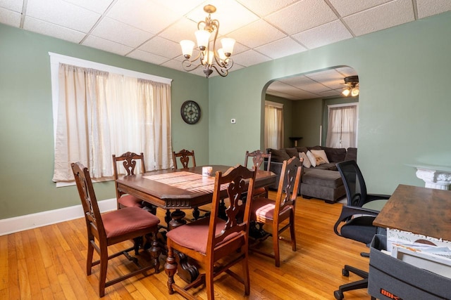 3011 16th St, Racine, WI 53405 - dining space featuring arched walkways, light wood-style flooring, a paneled ceiling, and a chandelier