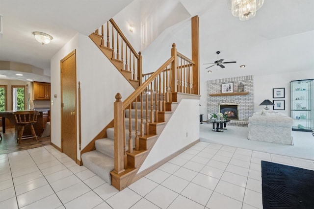 330 W Florida Ave, Appleton, WI 54911 - staircase featuring a brick fireplace, tile patterned floors, a ceiling fan, and carpet