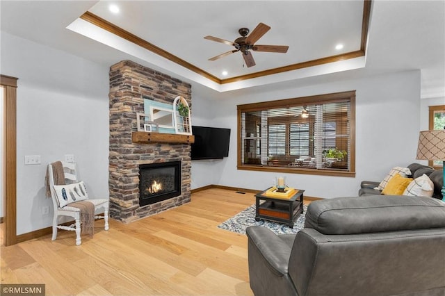 3735 Crest Ridge Ct, Eau Claire, WI 54701 - living area featuring a tray ceiling, crown molding, a ceiling fan, wood finished floors, and a fireplace