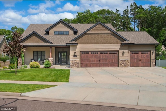 3735 Crest Ridge Ct, Eau Claire, WI 54701 - craftsman-style home featuring stone siding, a garage, concrete driveway, and a front lawn