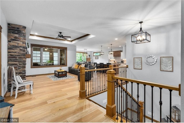 3735 Crest Ridge Ct, Eau Claire, WI 54701 - living area featuring light wood-type flooring, a chandelier, ceiling fan, and a raised ceiling