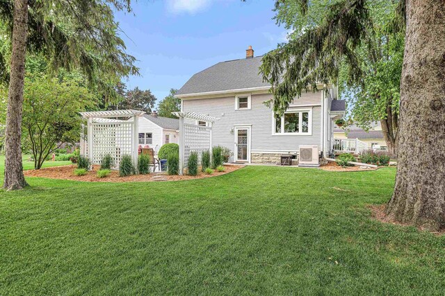 1515 Rugby St, Oshkosh, WI 54902 - back of property with a pergola, a chimney, a lawn, and roof with shingles