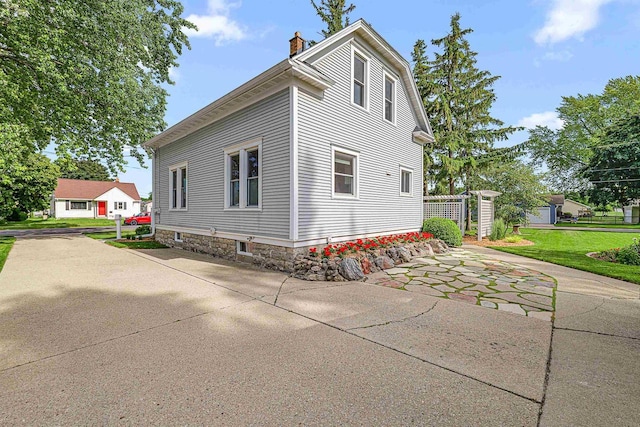 1515 Rugby St, Oshkosh, WI 54902 - view of home's exterior with a chimney, a yard, and a patio