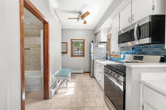1515 Rugby St, Oshkosh, WI 54902 - kitchen featuring appliances with stainless steel finishes, a ceiling fan, white cabinetry, and a baseboard heating unit