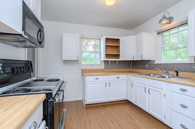 415 Broadway Ave, Wausau, WI 54403 - kitchen featuring black appliances, light wood finished floors, white cabinetry, plenty of natural light, and a wainscoted wall