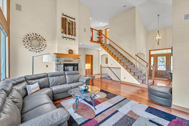 8668 47th Ave, Kenosha, WI 53142 - living room with a towering ceiling, stairs, wood finished floors, arched walkways, and a fireplace