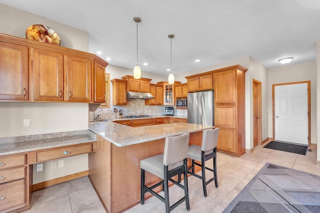 8668 47th Ave, Kenosha, WI 53142 - kitchen with stainless steel appliances, under cabinet range hood, a peninsula, glass insert cabinets, and a kitchen breakfast bar