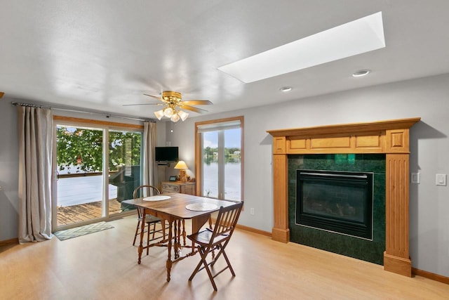 S7663 W Grandview Ave, Merrimac, WI 53561 - dining room with a skylight, light wood-style floors, a fireplace, ceiling fan, and recessed lighting
