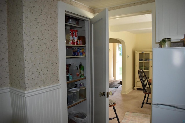 22630 Elm St, Cornucopia, WI 54827 - corridor featuring arched walkways, wainscoting, wallpapered walls, and light colored carpet