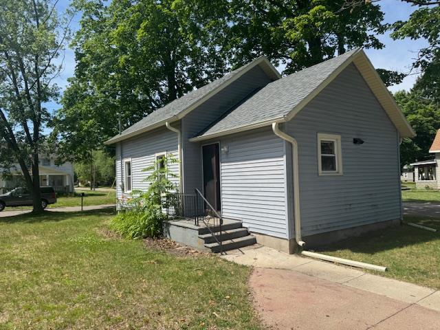 1225 Merrill St, Beloit, WI 53511 - view of front of house with a front lawn and a shingled roof
