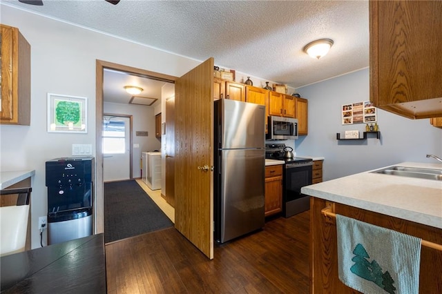 3950 Boardwalk St, Eau Claire, WI 54701 - kitchen featuring stainless steel appliances, dark wood-style floors, brown cabinetry, light countertops, and a textured ceiling