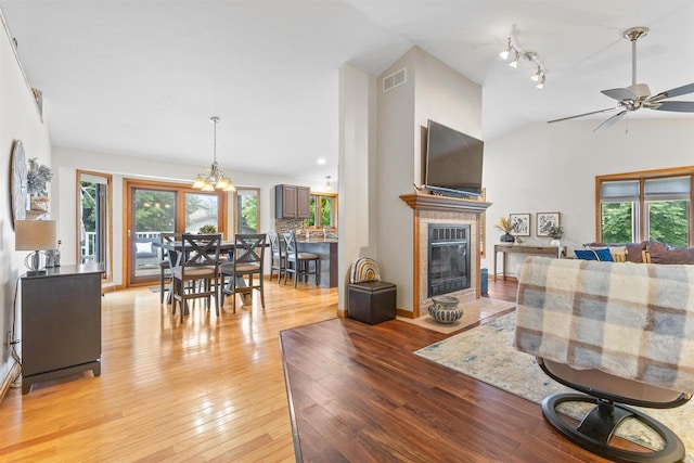 2570 Country Meadow Ct, Green Bay, WI 54313 - living area with healthy amount of natural light, ceiling fan, a tile fireplace, light wood finished floors, and vaulted ceiling