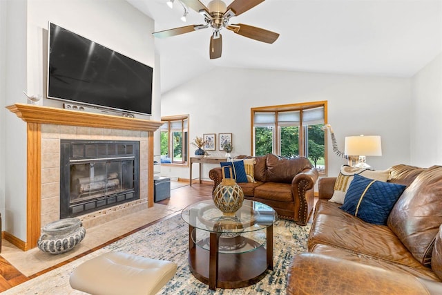 2570 Country Meadow Ct, Green Bay, WI 54313 - living room with vaulted ceiling, a ceiling fan, a tiled fireplace, and wood finished floors