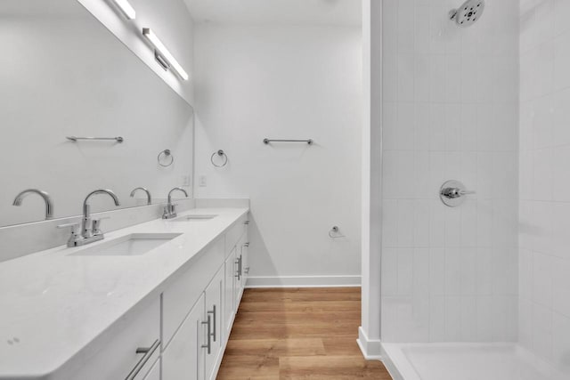 9352 S Alder Pl Unit 104, Oak Creek, WI 53154 - full bathroom featuring double vanity, a tile shower, and wood finished floors