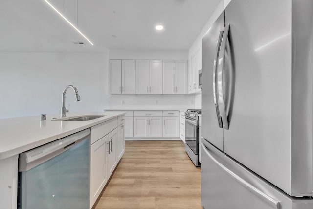 9352 S Alder Pl Unit 104, Oak Creek, WI 53154 - kitchen with appliances with stainless steel finishes, white cabinetry, light wood-type flooring, light countertops, and recessed lighting