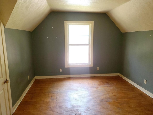 852 8th St, Beloit, WI 53511 - additional living space with wood-type flooring, vaulted ceiling, and a textured ceiling