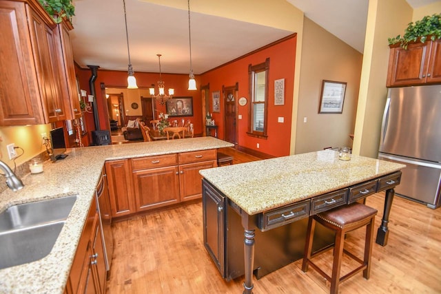 823 E Brandybrook Rd, Wales, WI 53183 - kitchen featuring freestanding refrigerator, light wood finished floors, brown cabinetry, a chandelier, and a peninsula