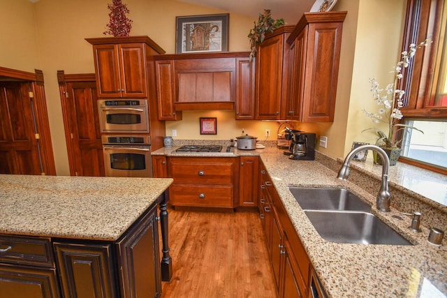 823 E Brandybrook Rd, Wales, WI 53183 - kitchen with stainless steel appliances, light wood-style flooring, light stone countertops, and custom exhaust hood